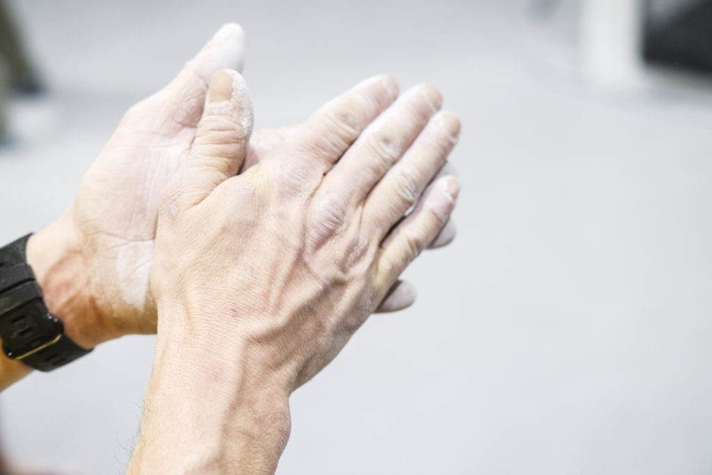 Hender med kalk før innendørs klatring for nybegynnere